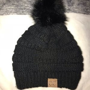 A beanie with a little puffball on top of it